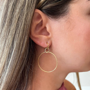 Female Model Wearing Interlocking Diamond Hoop Earrings Diamond Hoop Dangle Earrings -14K yellow gold weighing 3.37 grams -44 round pave-set diamonds totaling 0.13 carats.