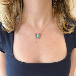 Female Model Wearing Emerald & Diamond Butterfly Pendant Necklace - 14K gold weighing 2.73 grams - 50 emeralds weighing 0.65 carats - 5 round diamonds weighing 0.06 carats