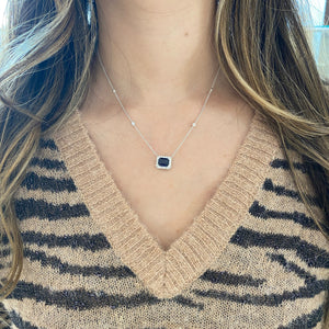 Female Model Wearing Emerald-Cut Sapphire Halo Diamond Pendant Necklace 18K gold weighing 4.79 grams 2.09 ct emerald-cut sapphire - 22 round diamonds weighing 0.44 carats