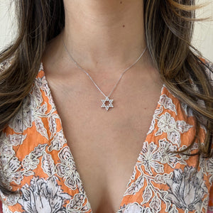 Female Model Wearing Round Diamond Star of David Pendant Necklace - 18K gold weighing 1.33 grams (pendant) - 14K gold weighing 1.60 grams (necklace) - 30 round diamonds weighing 0.62 carats